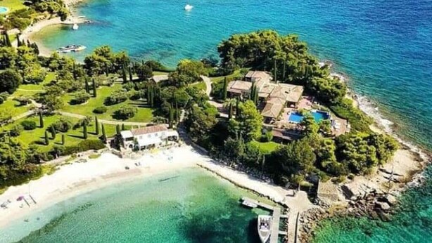 An aerial view of a coastal property with a beach, clear waters, and a small pier. - Amazing 2-bedroom Apartment Close to all Amenities (Ermionida)