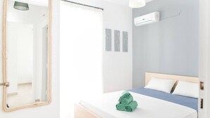 A bedroom with a bed, a mirror, and an air conditioning unit. - Amazing 2-bedroom Apartment Close to all Amenities (Ermionida)