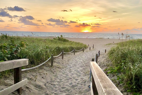 Una playa cerca, sillas reclinables de playa, toallas de playa