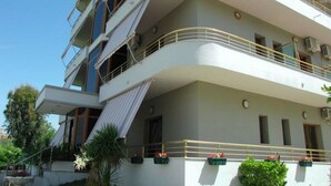A multi-story building with balconies, air conditioning units, and potted plants. - Denta Hotel (Orikum)