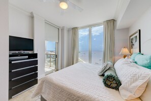 A bedroom with a bed, a television, a dresser, and a view of the beach. - P4-0709 2B Island View Elite Condo @ Portofino! (Pensacola Beach)