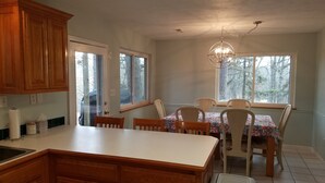 A kitchen with wooden cabinets, a dining table with chairs, and a chandelier.