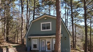 A two-story house with a green exterior, white trim, and a front porch.