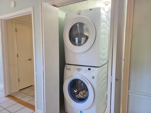 Una sala de bugaderia amb dues rentadores superposades.