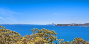 A coastal landscape with a clear view of the sea and distant land. - Randall Drive No 64 - Magnificent Views - Pool - Air con - WiFi - The list goes on! (Salamander Bay)