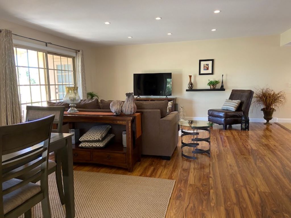 Un salon avec un canapé, un téléviseur, une table basse et un fauteuil.