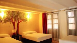 A hotel room with two beds, a nightstand, a lamp, and a wall-mounted tree decoration. - Casa Calli Hotel Restaurante Spa (San Pedro Cholula)