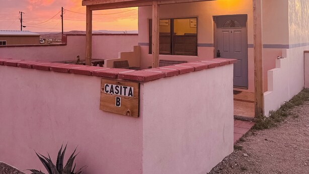 Un pequeño edificio con un letrero que dice "CASITA B" y un espacio al aire libre cubierto.