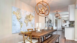 Un comedor con una mesa de madera, sillas y un mapa del mundo en la pared.