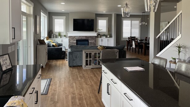 A spacious living area with a fireplace, a dining table, and a kitchen island. - Beautiful 3 bed+den, 3bath huge home on the Spokane River and Centennial Trail (Spokane Valley)