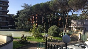 A residential area with a river, trees, and a building with balconies.