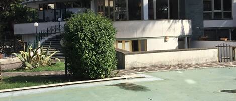 Un immeuble à plusieurs étages doté d’une façade incurvée, de grandes fenêtres et d’un balcon.