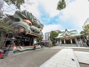 Un edificio tradicional con techo curvo y una gran estatua de dragón en su fachada.
