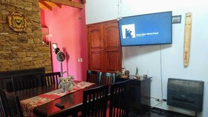 A dining area with a wooden table, chairs, and a television mounted on the wall. - House for rent for this summer 2021 in San Rafael Mendoza (San Rafael)