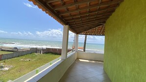 Ein überdachter Balkon mit Blick auf das Meer.