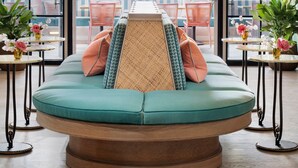 A modern lounge area with a central seating arrangement, large windows, and a ceiling light fixture. - the goodtime hotel, Miami Beach, a Tribute Portfolio Hotel (Miami Beach)