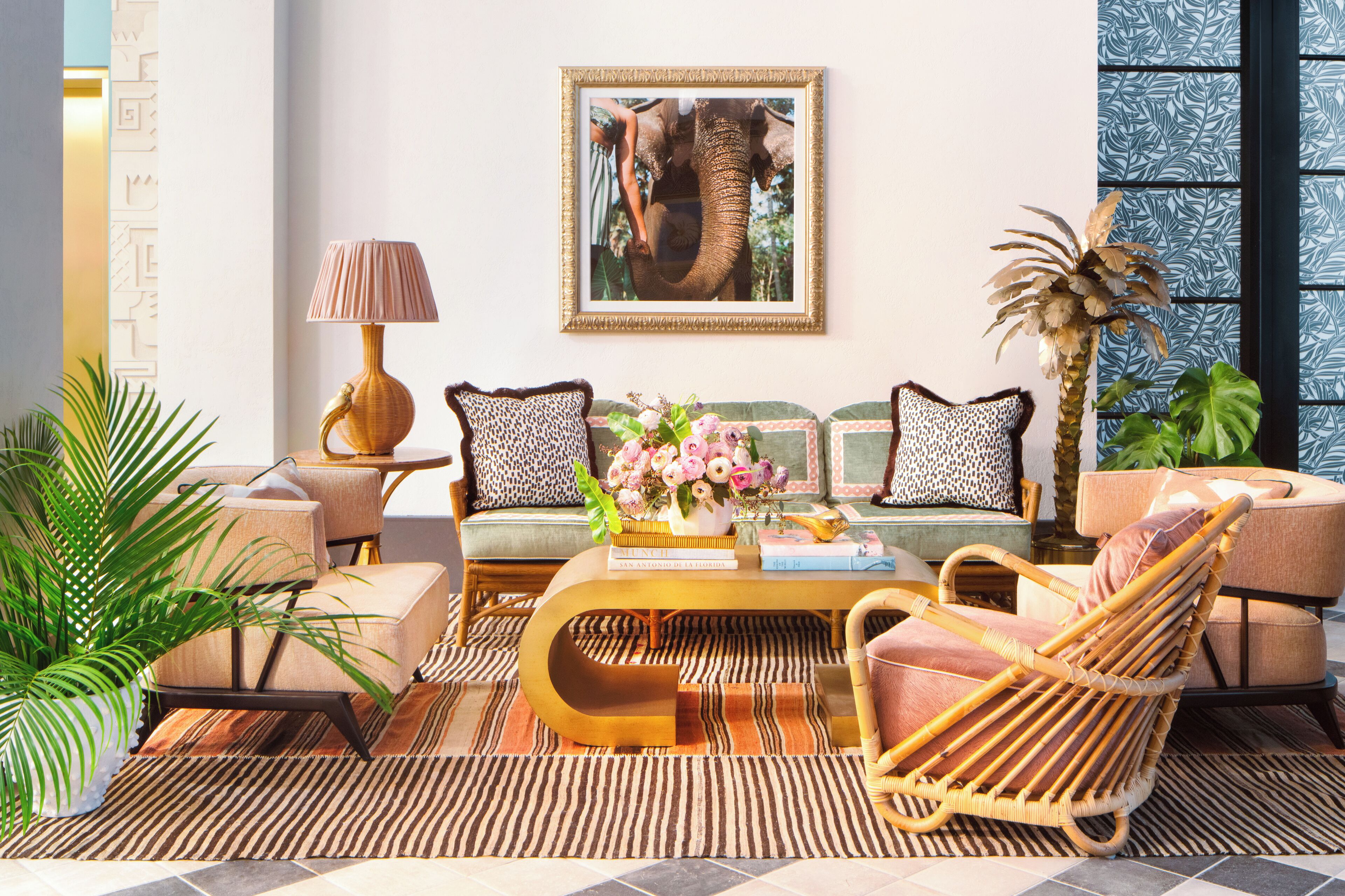 A well-lit living room with a sofa, chairs, a coffee table, and a large framed picture on the wall.