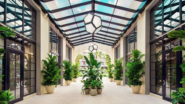 A covered atrium with a glass ceiling, large potted plants, and a geometric light fixture. - the goodtime hotel, Miami Beach, a Tribute Portfolio Hotel (Miami Beach)