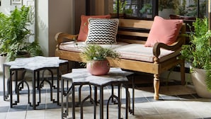 A cozy seating area with a wooden bench, black metal tables, and potted plants. - the goodtime hotel, Miami Beach, a Tribute Portfolio Hotel (Miami Beach)