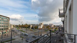 Un paisaje urbano con un edificio moderno, un cruce con tráfico y un cielo despejado.