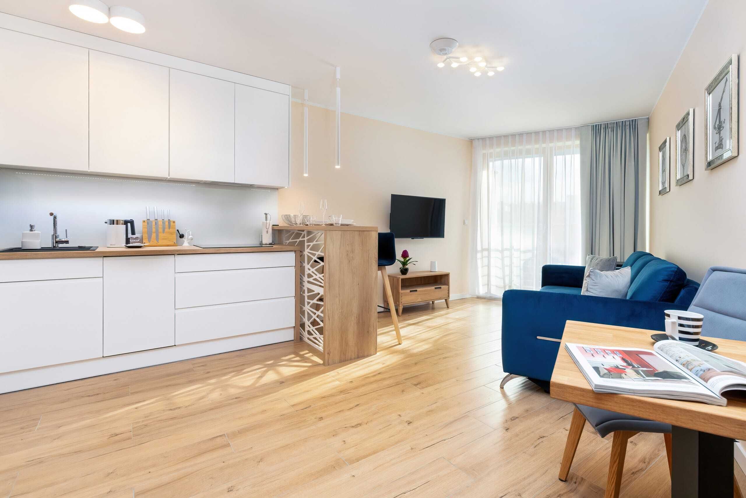A modern apartment with a kitchen, dining area, and living room.