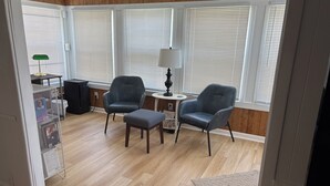 A room with two leather armchairs, a small table, and a lamp.