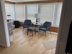 A room with two leather armchairs, a small table, and a lamp.