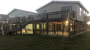 A two-story house with a balcony and a staircase leading to the upper floor. - Getaway By The Bay Unit 1 (Sargent)