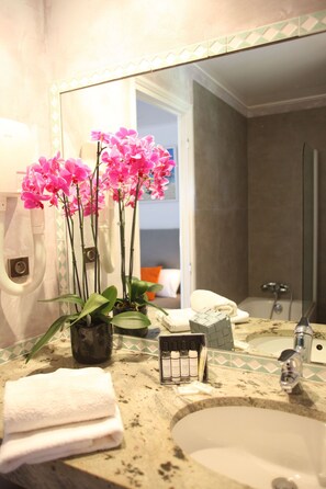 A bathroom with a sink, mirror, and a potted orchid plant. - Hotel Casa Rossa (L'Île-Rousse)