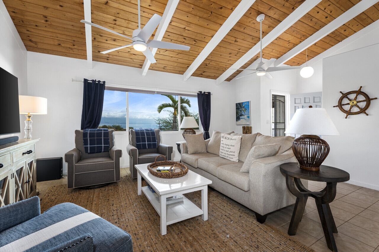 A living room with a wooden ceiling, a sofa, a coffee table, and a TV.