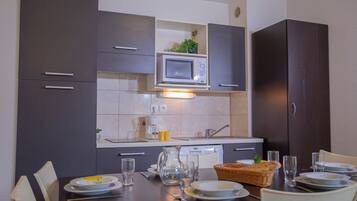 Een microgolfoven, een kookplaat, een vaatwasser, een broodrooster