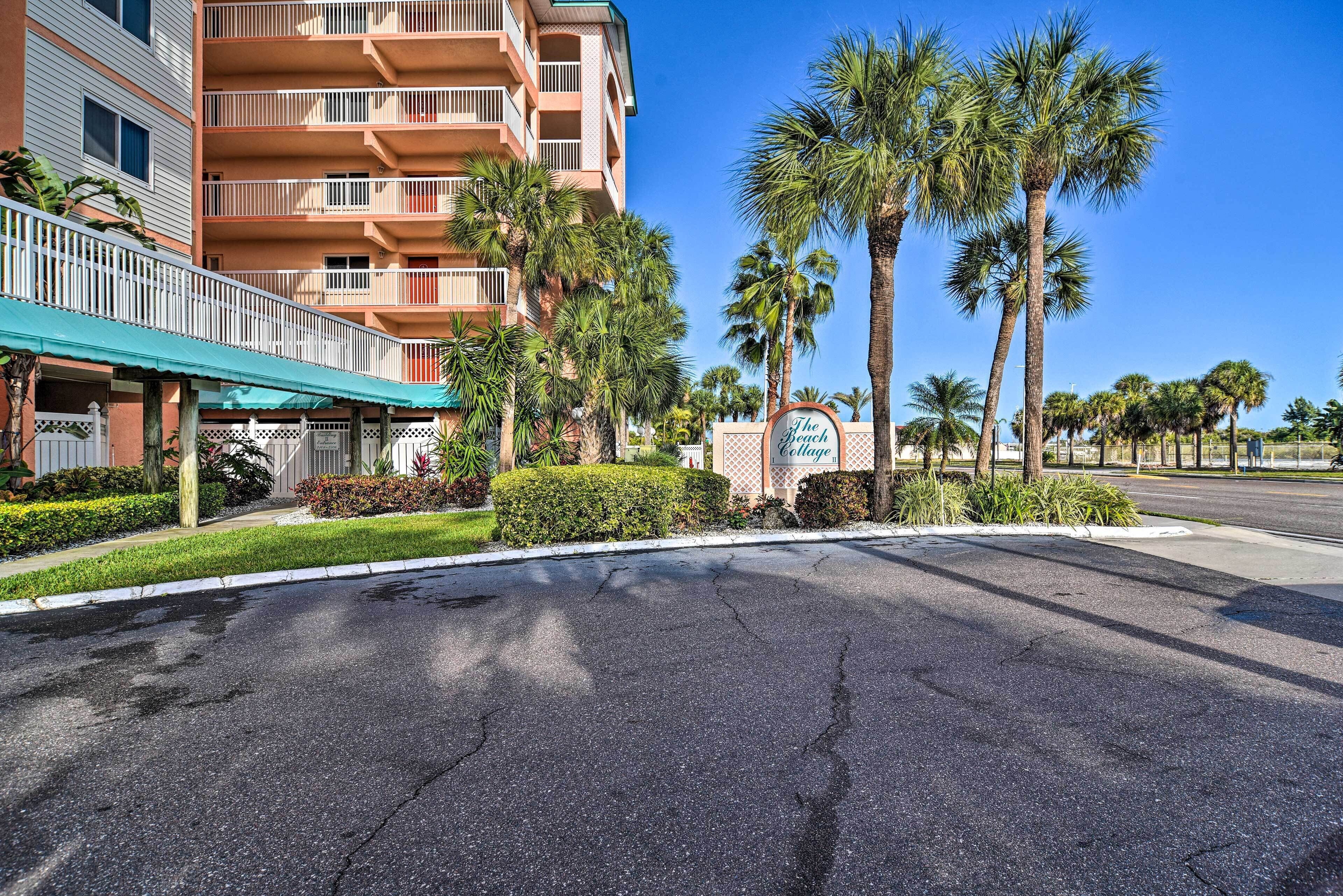 A hotel entrance with a sign reading "The Beach College," palm trees, and a multi-story building with balconies.