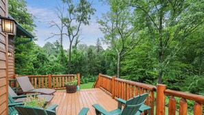 A wooden deck with green Adirondack chairs, a wooden railing, and a view of a forested area. - 2nd Largest Home @ Camelback “Occupancy is 20 with day guests included” (Tannersville)