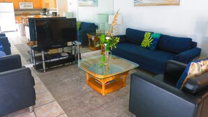 A living room with a TV, sofa, and coffee table.