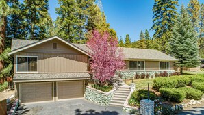 A two-story house with a garage, a stone staircase, and a well-maintained garden. - Spacious Cozy Home with private "HOT TUB" (Zephyr Cove)