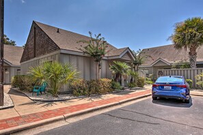 A residential street with a blue car parked in front of a house with a sloped roof and a small garden. - Coastal Resort Beach Villa < 1 Mi to Shore! (Hilton Head Island)