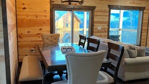Ein Holzinnenraum mit einem Esstisch, Stühlen und einem Sofa.