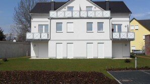 A two-story residential building with a symmetrical facade, white exterior, and a small balcony on the upper floor. - 2.3 - Glienbergweg 26 a Zinnowitz (Zinnowitz)