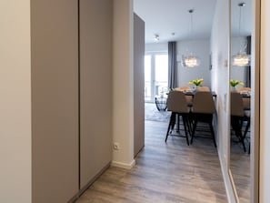 A modern interior with a dining area, light wood flooring, and pendant lighting.