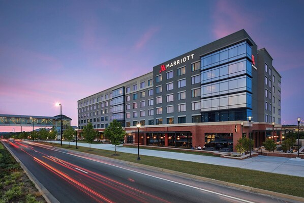A Marriott hotel with a modern design, featuring a large glass facade and multiple floors. - UNC Charlotte Marriott Hotel & Conference Center (Charlotte)