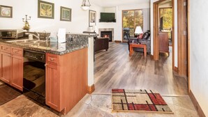 A modern kitchen with granite countertops, wooden cabinets, and a built-in dishwasher.
