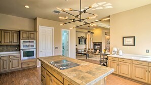 A spacious kitchen with a large island, built-in ovens, and a unique light fixture. - Mtn View! Group-Friendly Getaway in Fountain Hills (Fountain Hills)