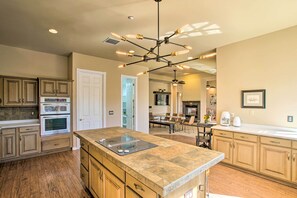 A spacious kitchen with a large island, built-in ovens, and a unique light fixture. - Mtn View! Group-Friendly Getaway in Fountain Hills (Fountain Hills)