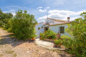 A house with a tiled roof, a small porch, and potted plants. - Holiday Home "Los Algarrobos Gaucin" with Mountain Views, Pool, Balcony & Terrace (Gaucin)