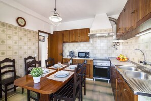 A kitchen with wooden cabinets, a microwave, an oven, and a sink.