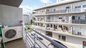 A multi-story residential building with balconies, air conditioning units, and potted plants. - Luminous Apartment Oura Nascente close to the Sea with Balcony & Wi-Fi (Albufeira)