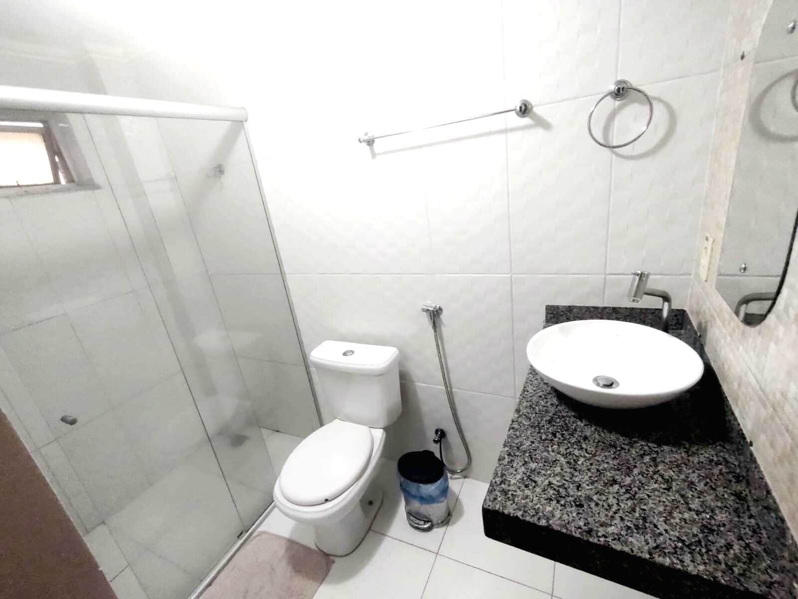 A small bathroom with a toilet, sink, and shower.