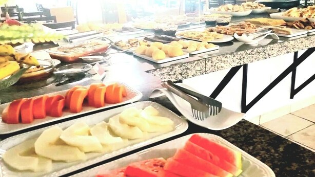 Un bufé con diversos alimentos, incluyendo frutas y verduras.