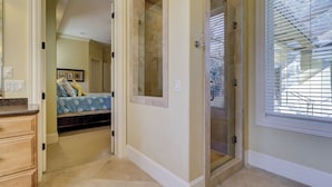 A bedroom with a bed, a dresser, and a walk-in closet.