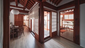 Une pièce de style japonais traditionnel, avec des poutres en bois, des portes coulissantes et un sol recouvert de tatamis.